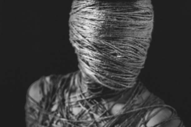 The social theme teen loneliness pain suffering. The head (face) and the body of a young man are tied with a rope. slenderman fictional character stock pictures, royalty-free photos & images