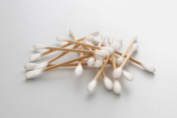 Cotton stick close-up over turquoise background with copy space.