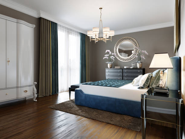 istock A modern bedroom in an eclectic style. With a double blue bed, black dressing table and chest of drawers with decor. beige walls and white wardrobe. 1249525377