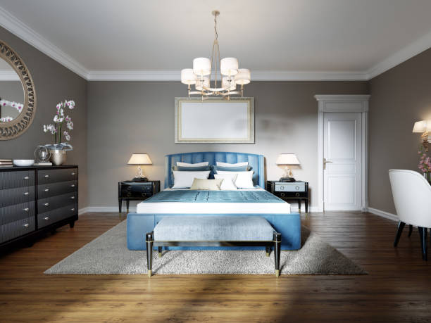 istock A modern bedroom in an eclectic style. With a double blue bed, black dressing table and chest of drawers with decor. beige walls and white wardrobe. 1249525554