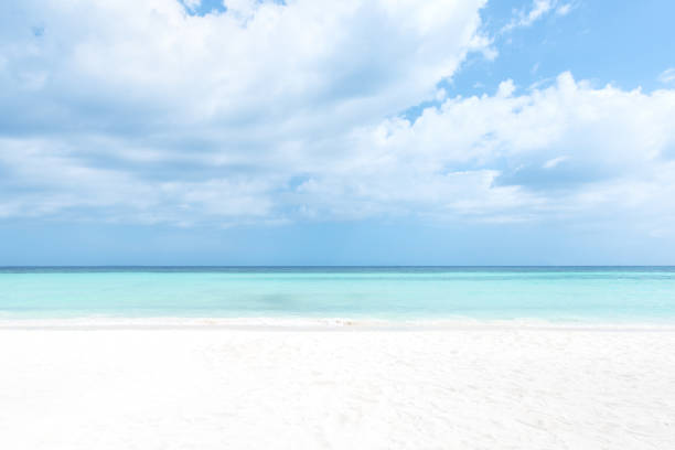 istock White sand beach and turquoise tropical sea with clouds sky 1249530613
