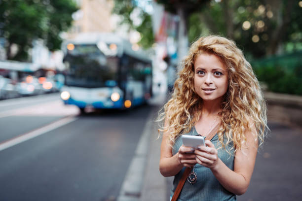 mulher millennial usando aplicativo móvel para compartilhamento de carona ou transporte público - bus public transportation sydney australia australia - fotografias e filmes do acervo