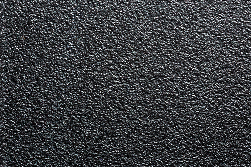 flat black rugged plastic or rubber surface with decorative bumpy finish.