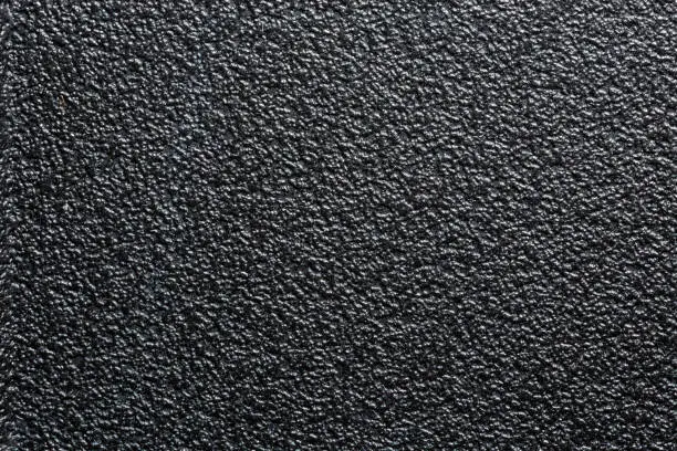 Photo of flat black rugged plastic or rubber surface with decorative bumpy finish