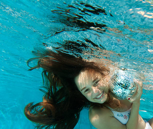 istock Girl with disco ball under water 124954409