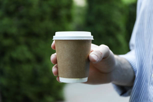 istock Young man holding a cup of coffee. Space for text 1249545415