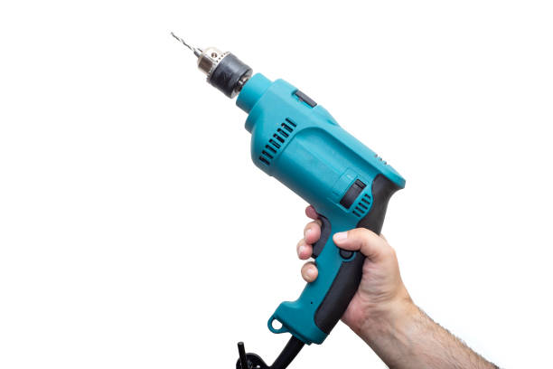 istock Men's hands hold a drill on a light background 1249548950