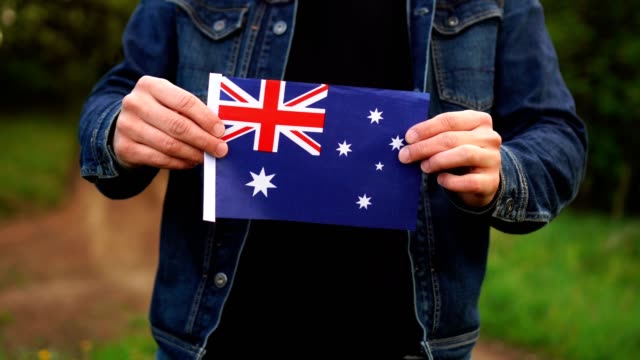 Man holding Australian flag outdoors. Independence Day, or national holidays concepts