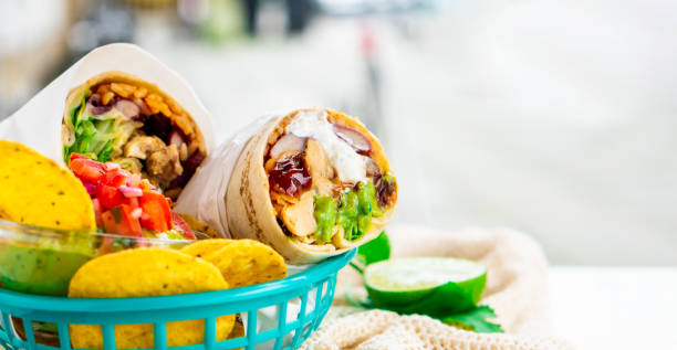 istock Mexican traditional authentic homemade Burrito with pulled pork beef chili con carne served with tomato salad and avocado guacamole and dip sauce 1249551020