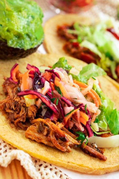 istock Mexican traditional authentic homemade tacos with pulled pork beef chili con carne serve with tomato salad and avocado guacamole and dip sauce 1249551471