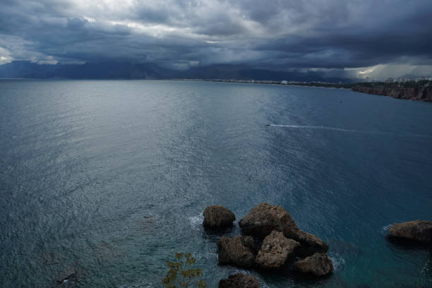 Dark blue sea clouds and rocks just before the rain