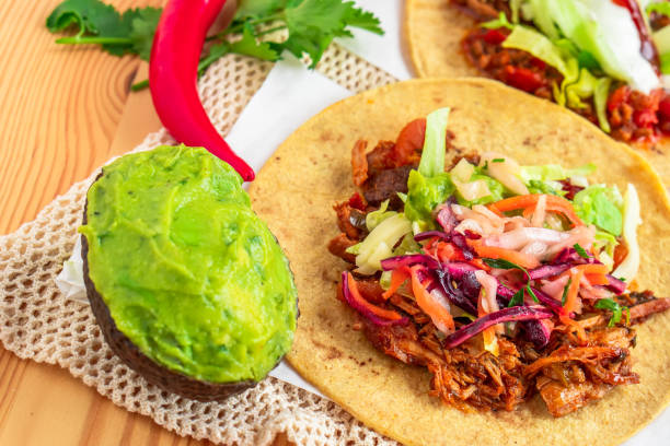 istock Mexican traditional authentic homemade tacos with pulled pork beef chili con carne serve with tomato salad and avocado guacamole and dip sauce 1249552074