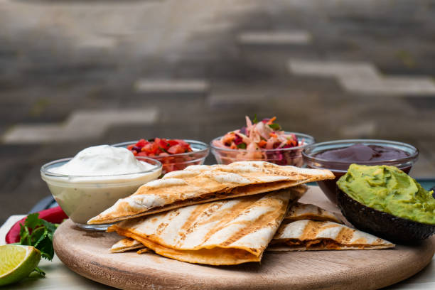 istock Mexican traditional authentic homemade quesadilla with pulled pork beef chili con carne serve with tomato salad and avocado guacamole and dip sauce 1249552537