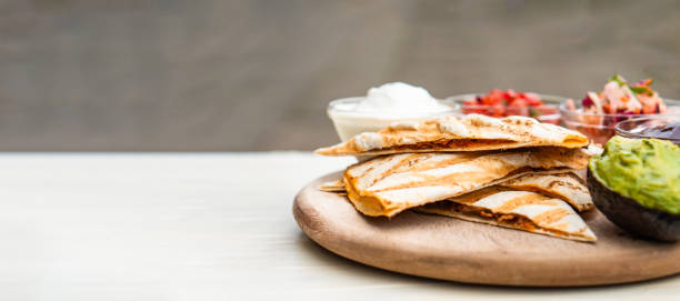 istock Mexican traditional authentic homemade quesadilla with pulled pork beef chili con carne serve with tomato salad and avocado guacamole and dip sauce 1249552544