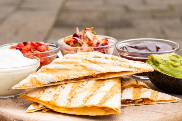 istock Mexican traditional authentic homemade quesadilla with pulled pork beef chili con carne serve with tomato salad and avocado guacamole and dip sauce 1249552598
