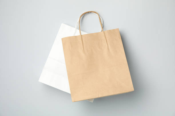 istock Empty paper bags on gray background, space for text. 1249555319
