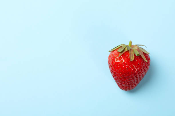 istock Tasty strawberry on blue background. Summer berry 1249555521