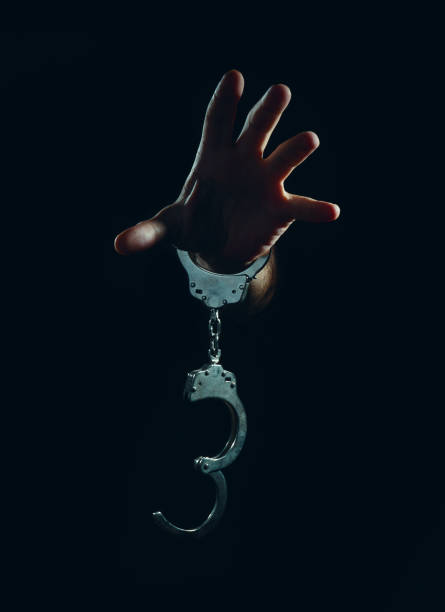 istock hands and handcuffs, in dark background. 1249558122