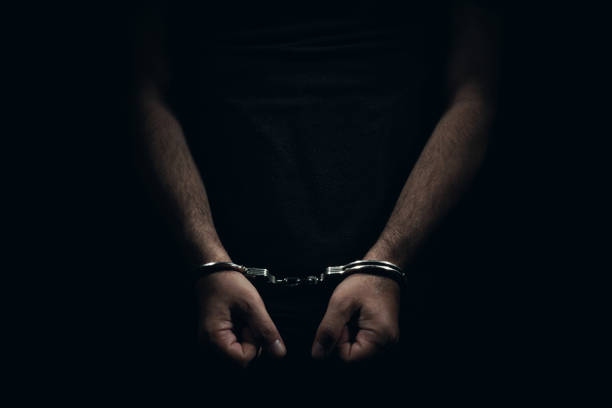 istock hands and handcuffs, in dark background. 1249558131