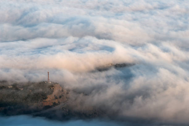 Communication tower over dense sea fog