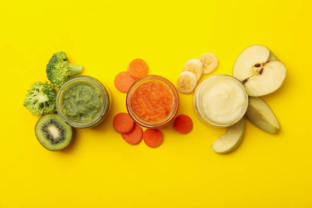 istock Composition with vegetable puree on yellow background. Baby food 1249561201