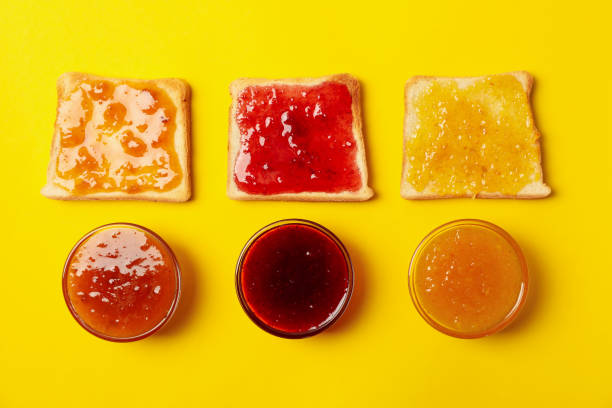 istock Toasts and bowls with jam on yellow background, top view 1249566277
