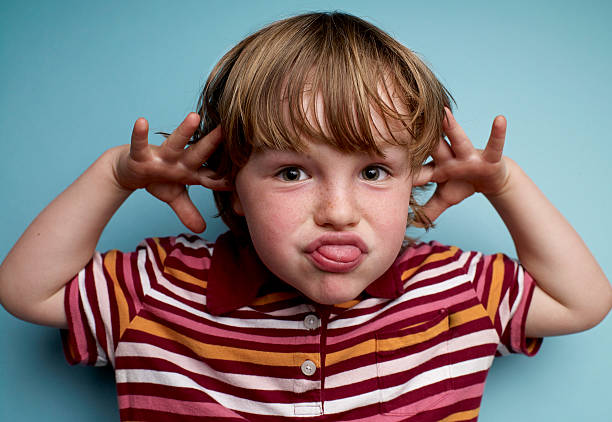 young boy making face - een gek gezicht trekken stockfoto's en -beelden