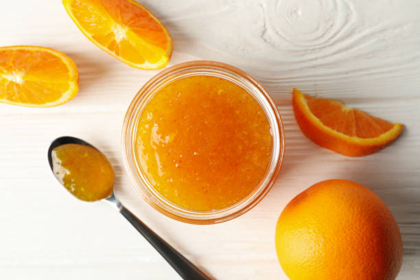 istock Oranges, spoon and glass jar with jam on white wooden background 1249566766