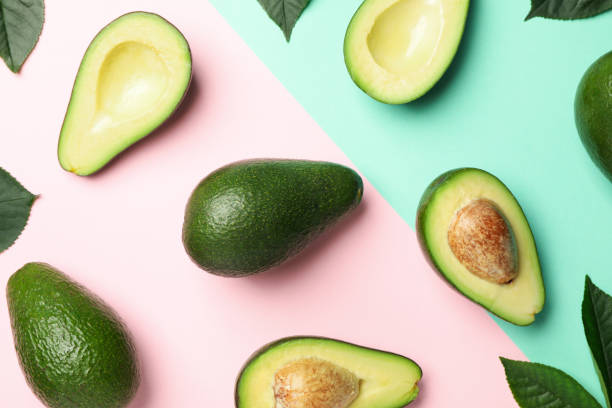 istock Flat lay with avocado and leaves on two tone background, top view 1249568512