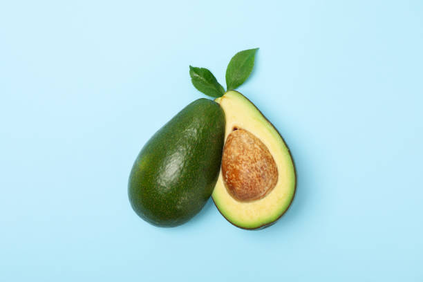istock Ripe fresh avocado on blue background, top view 1249569640