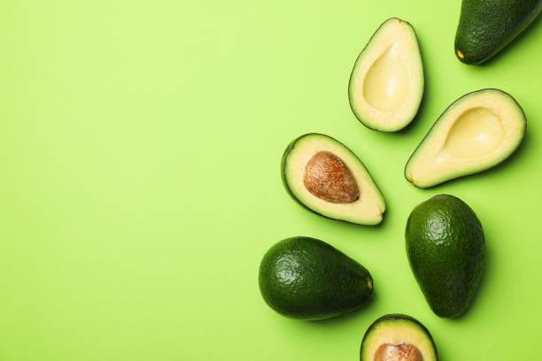 istock Ripe fresh avocado on green background, top view 1249570145