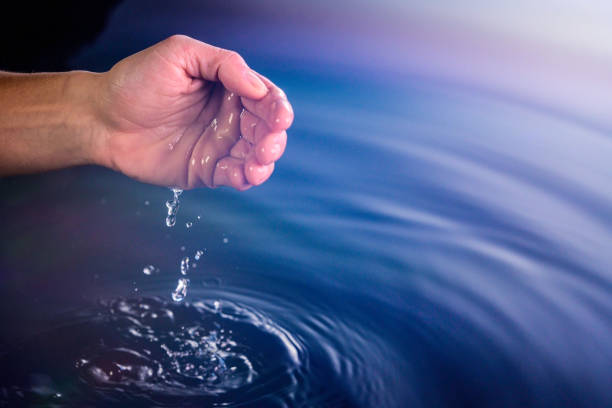 istock Hand playing with water from a pond 1249571588