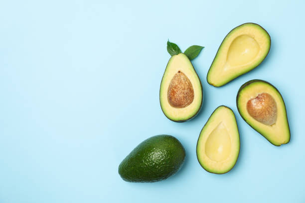 istock Ripe fresh avocado on blue background, top view 1249571765