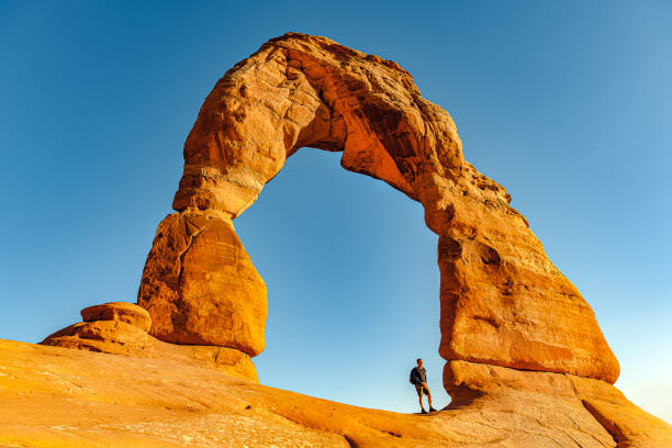 Man Enjoying Delicate Arch in Utah ,USA Man Enjoying Delicate Arch in Utah ,USA,Nikon D3x slickrock trail stock pictures, royalty-free photos & images