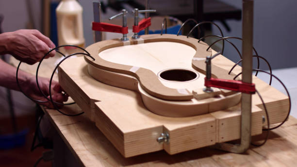 istock Luthier uses springs to clamp guitar body 1249577796