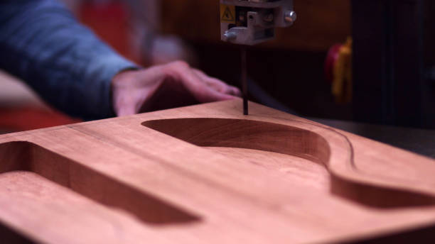 carpenter utiliza sierra de banda para cortar tablones de madera - fabricante de instrumentos fotografías e imágenes de stock