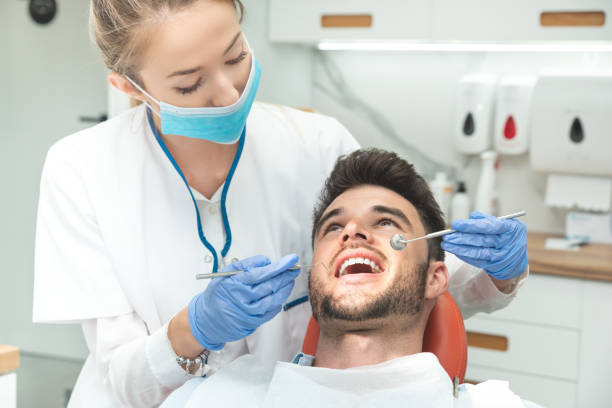 uomo con i denti esaminati dai dentisti - igienista dentale foto e immagini stock