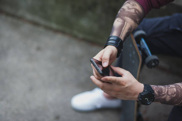 Skateboarder enjoying a free time using a phone
