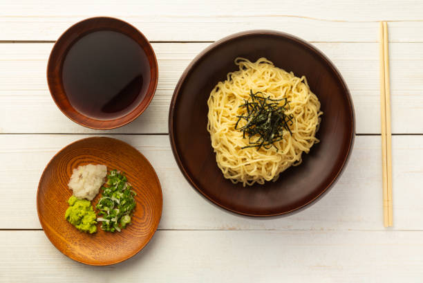 fideos de ramen frío japonés o "zaru soba" con cebollas verdes picadas, wasabi rallado y taza para sumergir la salsa vista superior sobre fondo de madera con espacio de copia - bamboo brown cooking gourmet fotografías e imágenes de stock