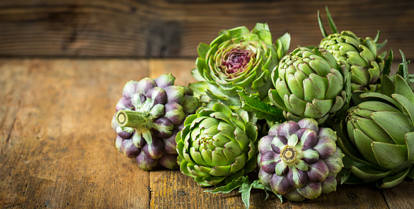 Fresh and raw artichoke on the wooden table