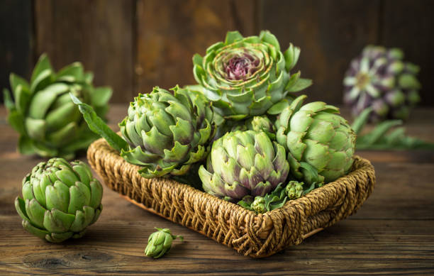 istock Fresh and raw artichoke on the wooden table 1249586294
