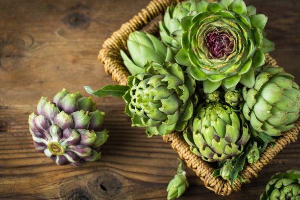 istock Fresh and raw artichoke on the wooden table 1249586295
