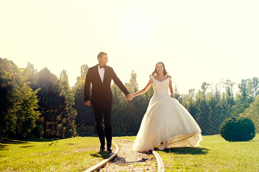 Just married couple walking on a railroad. bride and groom