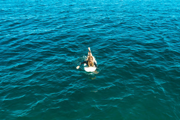 istock Girl on the surfboard drone shot 1249587897