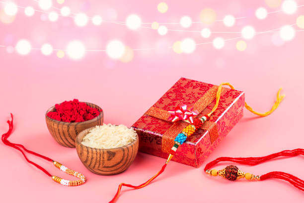 Indian festival Raksha Bandhan Indian festival Raksha Bandhan background. Indian rakhi bracelets, presents, rice and kumkum in bowls on white. Copy space rakhi stock pictures, royalty-free photos & images