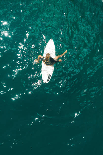 istock Girl on the surfboard drone shot 1249588920