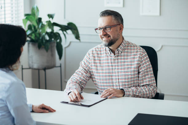 istock Handsome senior boss interviewing an elegant business woman 1249588974