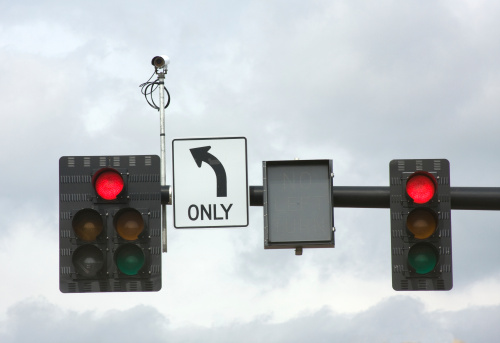 Traffic Signals and Camera Against a Cloudy Sky