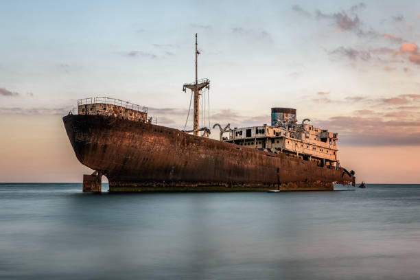 Shipwreck at the sunset Shipwreck at the sunset on a Lanzarote coast with copy space ship wreck shore storm stock pictures, royalty-free photos & images