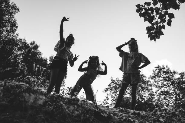 Happy three friends playing at the park. Monochrome version.